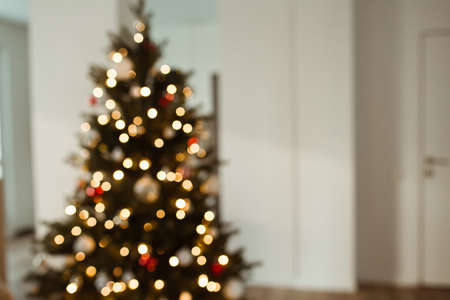 Blurred light on Christmas tree. Bright glow gold bokeh.の写真素材