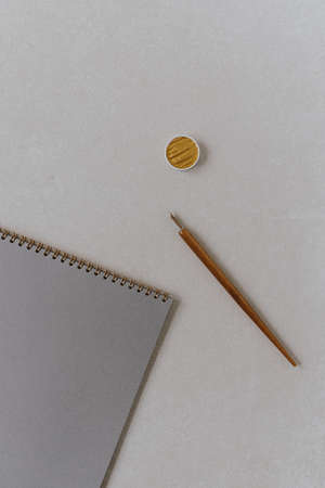 Flatlay blank paper sheet notebook, fountain pen, golden ink on beige concrete background....