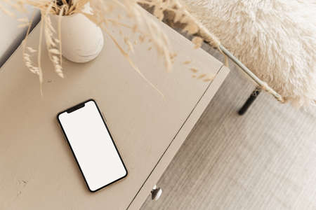 Flatlay of blank screen mobile phone on beige pastel table. Flat lay, top view. Copy space mockup template.の写真素材