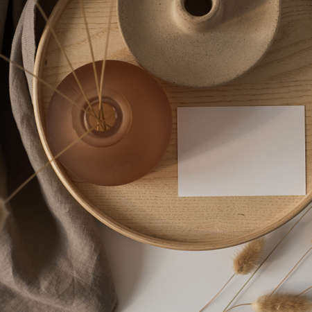 Blank paper sheet card with mockup copy space and bunny tail grass on wooden casket and gray linen blanket. Aesthetic business brand, blog, social media template background. Flat lay, top viewの写真素材