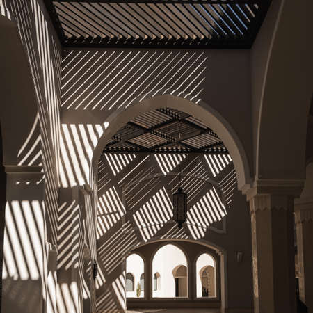 Modern east style building with beige walls, windows and rail sunlight shadows. Aesthetic abstract architecture interior designの写真素材