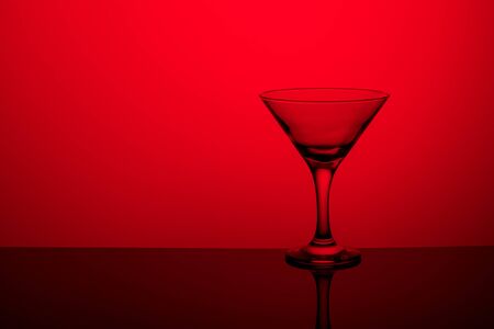 Glass goblet without wine on a thin leg stands on a mirror surface.の写真素材