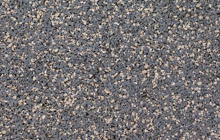 Pebble stones background, dark gravel texture close up, top view