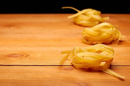 Raw uncooked nest pasta on the homemade wooden tableの写真素材