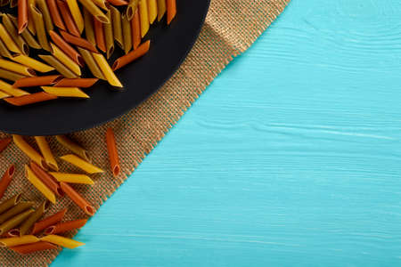 Raw pasta on a black plate, top view, copy spaceの写真素材