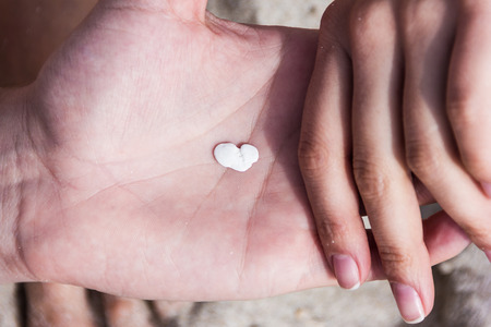 The white stone in the shape of a heart in his hand