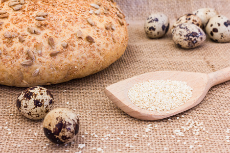 Fresh quail eggs with rye bread on sackclothの写真素材