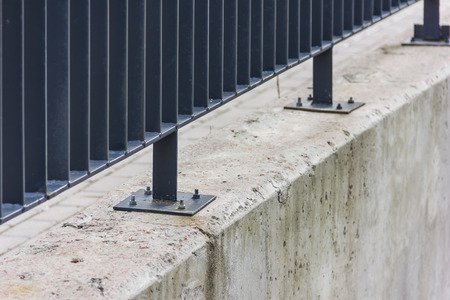 Metal fence on a concrete wallの写真素材