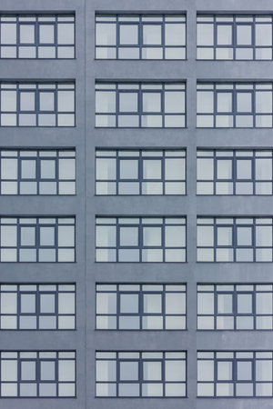 Dark grey facade of building with grey big windows. Apartment block. Family. Real estateの写真素材