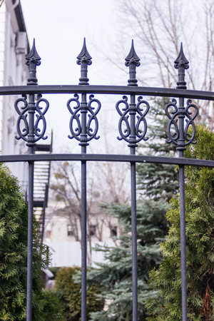 Black metallic forged fence with spikes. Gardenの写真素材