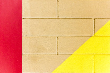 Yellow and brown brick wall texture with red line. Three-color abstract backgroundの写真素材
