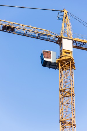 High tower crane against the blue sky. Fragment of a craneの写真素材