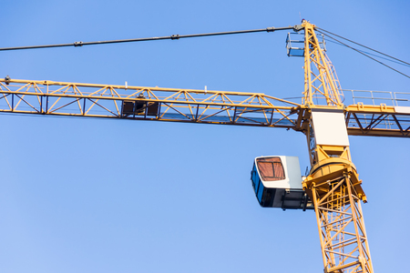 High tower crane against the blue sky. Fragment of a craneの写真素材