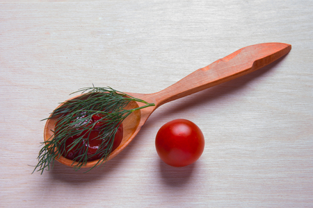 Tasty ketchup in wooden spoon isolated on whiteの写真素材