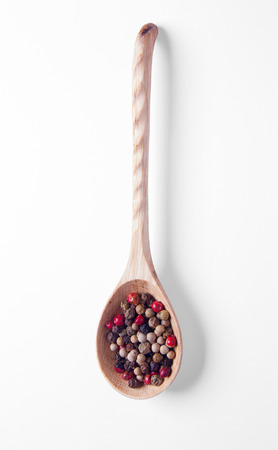 Wooden spoon filled with various spices on white backgroundの写真素材