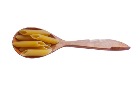 Spoon filled with dry pasta over whiteの写真素材