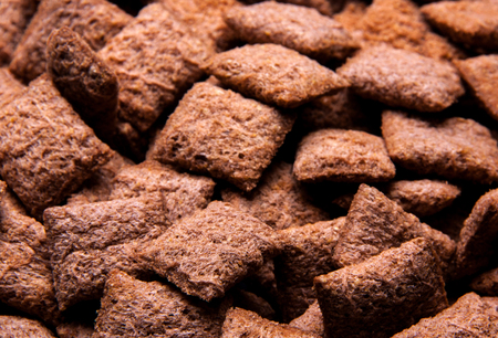 Chocolate breakfast cereal texture. Cereal balls as background. Chocolate corn balls wallpaper...