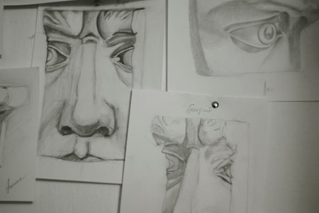 a person's face drawn in pencil on the wall. Black and white photo. Academic drawing at school