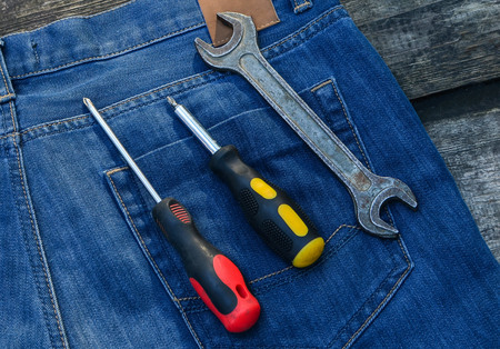 Mechanics Tool Set. Screwdriver and wrench in a pocket of blue jeans. Tools for general repair. Buildingの写真素材