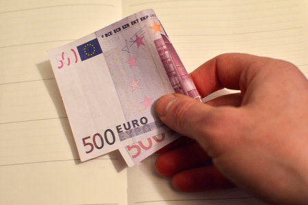Man's hand holding a big money bill, 500 euros in one hand. The bill of 500 euros out of circulationの写真素材