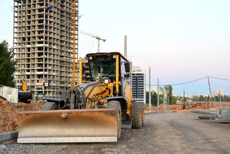 Ð¡onstruction machine Motor Grader at a construction site level the ground and gravel stones for...