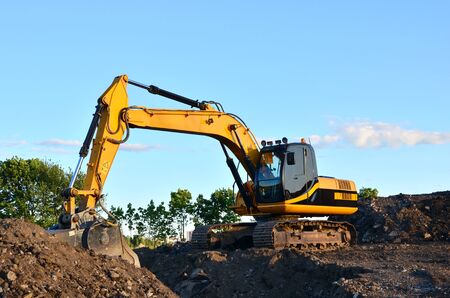Excavator with crusher bucket for crushing concrete. Construction waste recycling for construction mix. Sifting and grinding bucket for the separation of concrete into fractions of higher quality.の写真素材