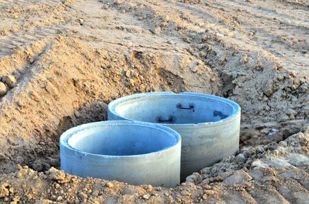 Installation of concrete sewer wells in the ground at the construction site. The use of reinforced...