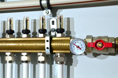 Close up of manometer, pipe, flow meter, water pumps and valves of heating system in a boiler room at home. Systems of water floor heating of  houses. Underfloor Heater Manifolds, background, textureの写真素材
