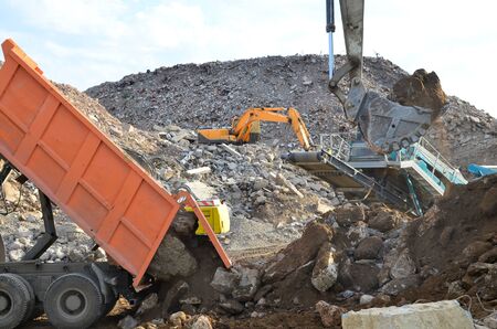 Dump truck unloading of broken concrete slabs demolition waste on landfill. Reuse concrete....