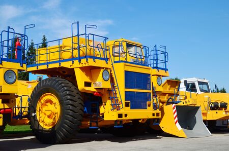 Heavy-duty trucks warehouse at autoworks. Giant mining dump trucks manufacture by the heavy vehicle plant. Heavy quarry equipment. Coal mining, granite, gravel, sand.の写真素材