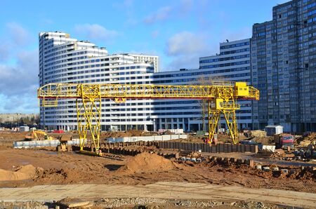 Gantry crane working at construction site. Digging a pit for the building of an underground tunnel...