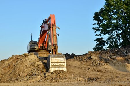 Excavator at a construction site during earthworks and laying of underground pipes. Professional excavation contractor serving, trenching, grading for residential, commercial, and municipal projects.の写真素材