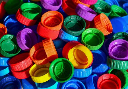 Plastic bottle caps background. Cap material is recyclable.Remove lids from plastic bottles before recycling them. Recycling collection and processing plastic bottle capsの写真素材