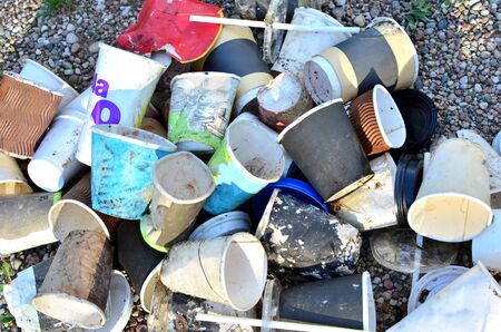 Discarded cups of coffee, cola and other beverages on the ground, background, abstraction. People...