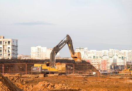 15.01.2020 Minsk, Belarus: Excavator VOLVO EC 350 DL digs ground at a construction site for installing concrete storm pipes. Backhoe the digging pipeline ditch. Commercial and Public Civil Workのeditorial素材