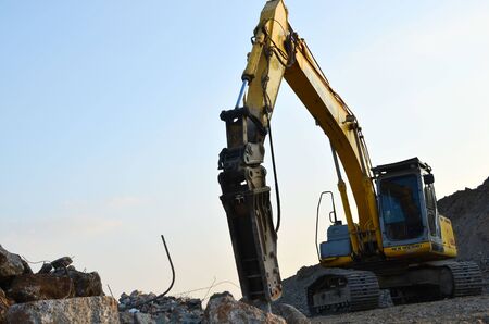 Minsk, Belarus 02.09.2019: Excavator New Holland E215B with hydraulic breaker hammer for the...