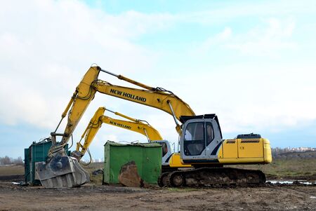08.11.2019. Minsk, Belarus: Excavators "New Holland" with crusher bucket for crushing concrete on construction site.  Sifting and grinding bucket for the separation of concrete into fractionsのeditorial素材