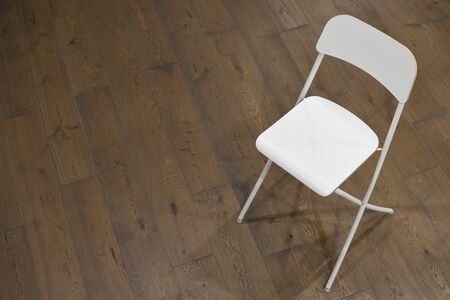 White wooden chair with a back on the floor in the roomの写真素材