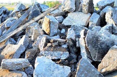 Broken pieces of asphalt at a construction site. Recycling and reuse crushed concrete rubble, asphalt, building material, blocks. Crushed Ñoncrete Background. Road repair, replacement of old pavementの写真素材