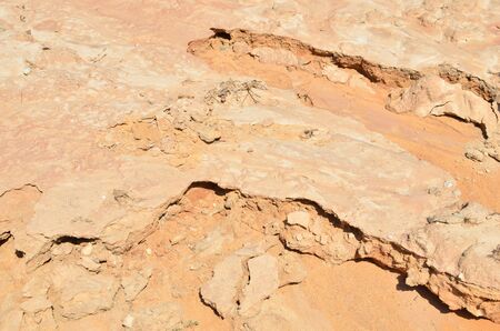 Shattered sand in the ground as a result of heavy torrential rains. Dry cracked soil of the earth...