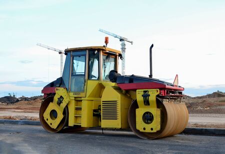 Road roller working at construction site during asphalt road repair. Paving roller machine on paving...