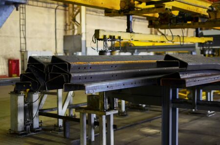 Industrial workshop of a forging plant for the production of truck frame chassis and parts accessories. Metal chassis on assembly line of the factory. Small roughness sharpness, possible granularity.の写真素材