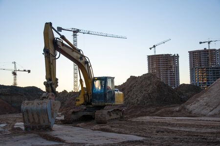 Track-type excavator during earthmoving at construction site. Backhoe digg ground at construction...