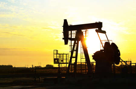 Oil drilling derricks at desert oilfield for fossil fuels output and crude oil production from the ground. Oil drill rig and pump jack backgroundの写真素材