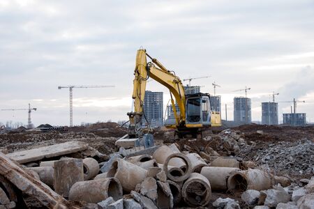 Excavator with crusher bucket for crushing concrete. Construction waste recycling for construction...