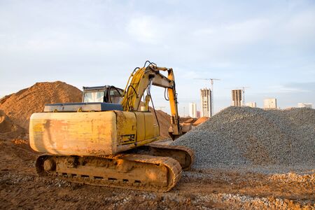 Excavator at earthworks on construction site. Backhoe loader digs a pit for the construction of the...