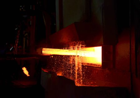 Steel quenching at high temperature in industrial furnace at the workshop of a forge plant. Process...