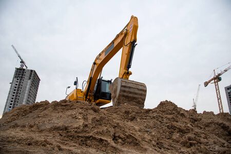 Track-type excavator during earthmoving at construction site. Backhoe digging the ground for the...