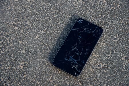 Mobile smartphone with a broken screen on the ground. Repair Gadgets Backgroundの写真素材