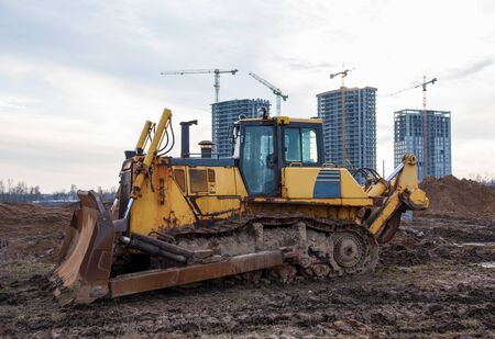 Track-type bulldozer during of large construction jobs at building site. Land clearing, grading,...